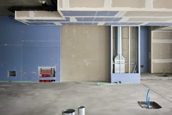 Rohbau eines Raums mit unvollendeten Wänden und sichtbarer Elektroinstallation.